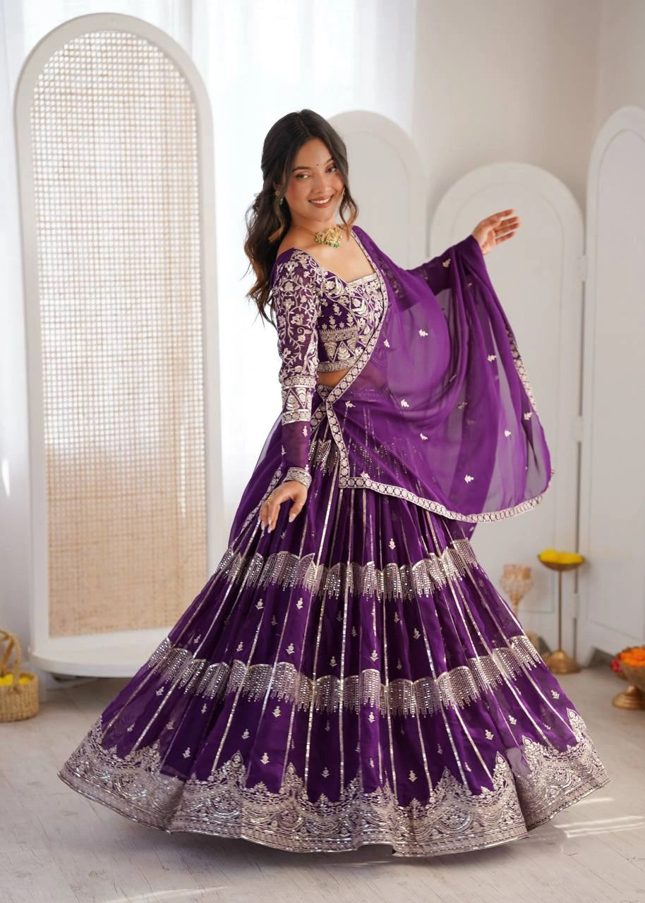 Woman in a traditional purple and silver outfit standing in a well-lit room.